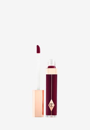 Rossetto liquido con un colore bordeaux profondo e lucido. Il tubo presenta un accento dorato e un applicatore bianco con punta appuntita.
