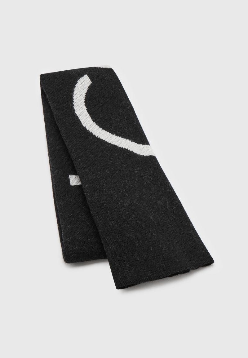 Écharpe en tricot noire pliée avec un motif partiel de ligne blanche courbée sur un fond clair uni.