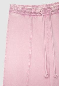 Pantaloni da jogging rosa con vita elasticizzata e coulisse, tessuto morbido e motivo sfumato sottile, adatti per un look casual.