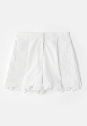 White shorts featuring a textured embroidered design along the sides and scalloped hem. Smooth fabric with decorative bead accents.