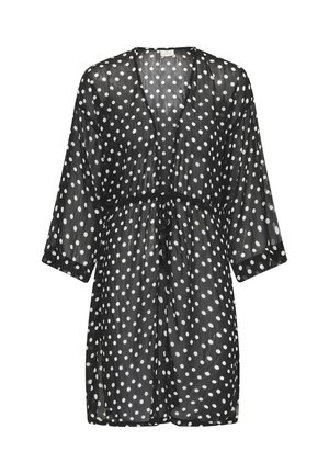 Robe noire transparente longueur genou avec des pois blancs, manches trois-quarts et ceinture à nouer devant.