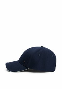 Gorra de béisbol azul marino con visera curva, textura de tela y pequeña etiqueta de logo en la parte delantera. Presenta agujeros de ventilación cosidos y franjas.