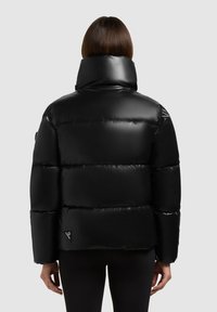 Juodas pūkinis džemperis su aukštu apykakle, blizgiu paviršiumi ir siuvinėtomis sekcijomis. Pridedama logotipo ženklelis apatinėje pusėje. Pavaizduota atgal.