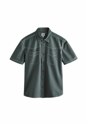 Short-sleeve shirt in dark green, made of textured fabric. Features two front pockets and visible stitching along the seams and collar.