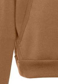 Bruine sweatshirtstof met een gladde textuur, geribbelde manchetten en stikseldetails langs de naden, met een relaxed-fit ontwerp.