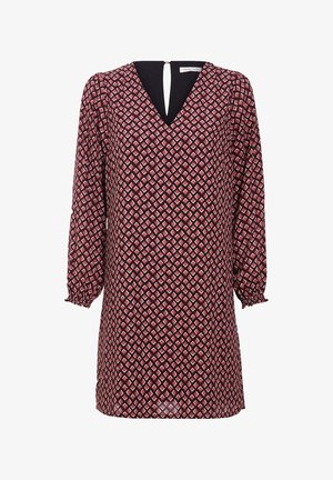 Robe à manches longues avec motif losanges rouges et blancs, col en V, poignets froncés et une partie en tissu noir à l’intérieur du décolleté.