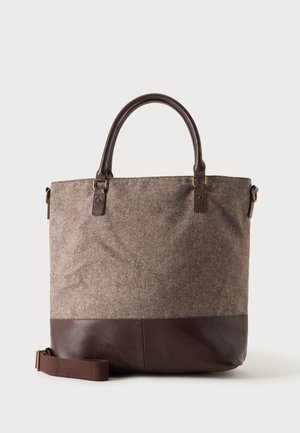 Sac fourre-tout en tissu marron avec motif chevrons, base et poignées en cuir marron foncé, et une bandoulière ajustable.