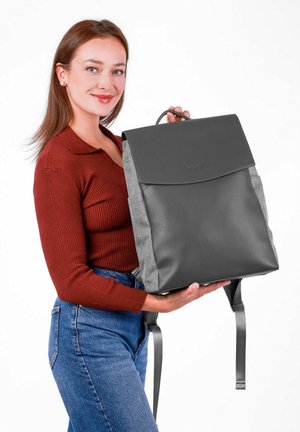 Šedý a černý batoh s hladkým povrchem a bočními kapsami, s klopou a ramenními popruhy. Vyroben z kombinovaných materiálů.