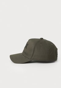 Casquette de baseball vert olive avec une visière incurvée, arbore un texte noir portant l'inscription "FLX EXCHANGE", sur un fond blanc.