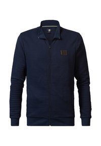 Navy zip-up jacket with ribbed texture, stand collar, and fitted cuffs. Features a small logo patch on the left chest.