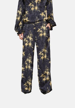 Sort og gylden mønstret to-delt sæt med flydende stof, der har lange ærmer og brede bukser, prydet med et blomsterdesign.