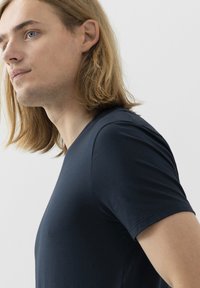 T-shirt a maniche corte blu navy con scollo a V realizzato in tessuto morbido, caratterizzato da una silhouette aderente e una texture liscia. Design semplice senza motivi.