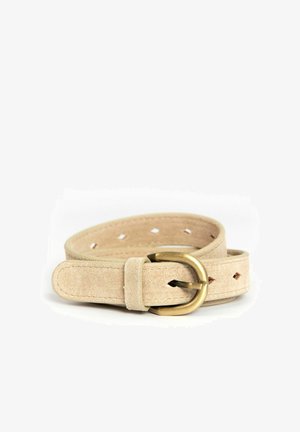 Ceinture en daim beige avec boucle en laiton arrondie, plusieurs trous en forme de losange et bords cousus, enroulée sur un fond blanc.