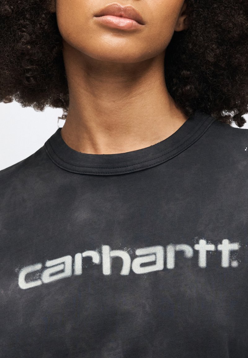 Sort tie-dye t-shirt med stort, falmet hvidt "carhartt" logo. Blødt stof med rund halsudskæring og korte ærmer.