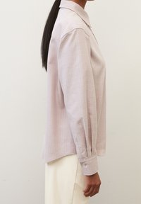 Camicia a maniche lunghe rosa chiaro con colletto, polsini abbottonati, sottile texture e orlo curvato, realizzata in tessuto morbido.