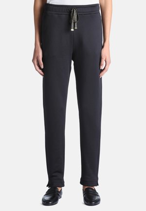 Pantalon noir droit avec taille à cordon, porté avec des chaussures noires sans lacets, montré du milieu du torse jusqu'aux pieds sur un fond blanc.