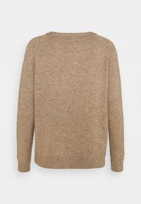Beżowy sweter dziany z ribbowanym dołem i mankietami, z okrągłym dekoltem i długimi rękawami. Miękka tekstura widoczna w tkaninie.