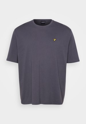 T-shirt de algodão cinza escuro com decote redondo e mangas curtas. Apresenta um pequeno emblema amarelo no peito. Corte casual e textura suave.