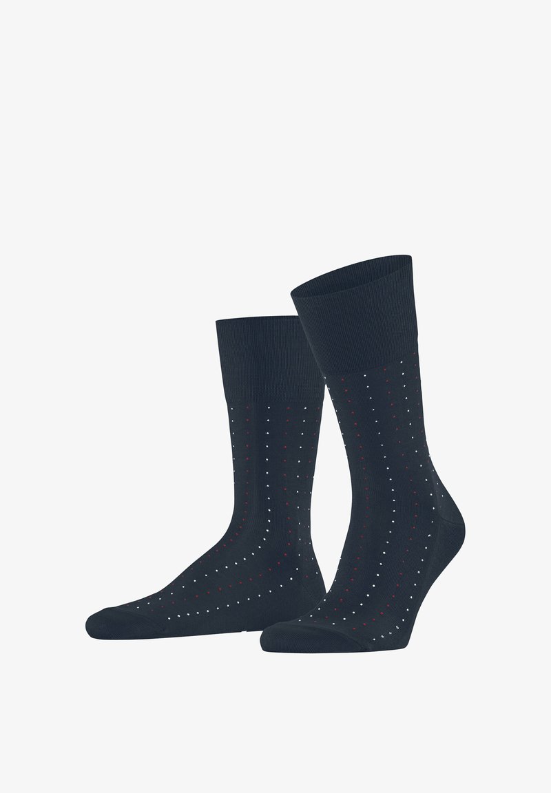 Granatowe skarpety do połowy łydki z małymi białymi i czerwonymi kropkami ułożonymi w pionowe linie.