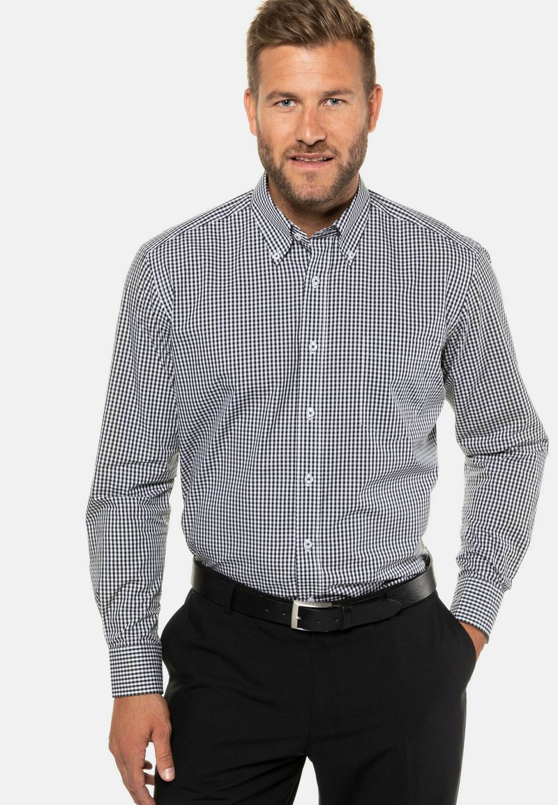 Zwart-wit geblokt overhemd met een button-down kraag, lange mouwen en een slim-fit ontwerp; gedragen met een zwarte riem en broek.