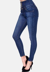 Hoge taille blauwe denim jeans met vijf knopen, slim fit en contrasterende stiksels. Heeft een gladde textuur en twee achterzakken.
