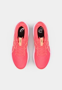 Bright pink athletic shoes with a mesh upper, rubber sole, and neon orange accents, featuring lace-up design and cushioned insole.