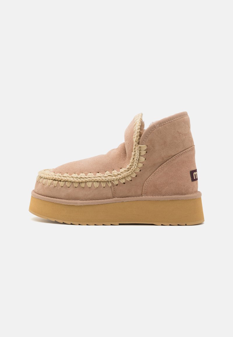 Botas de cano curto em camurça de cor rosa claro com um design trançado texturizado ao longo da borda e uma sola grossa de borracha em uma cor castanha contrastante.