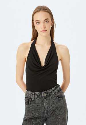 Body con nero con scollo a halter, abbinato a jeans neri a vita alta con dettagli in glitter argento e una finitura testurizzata.