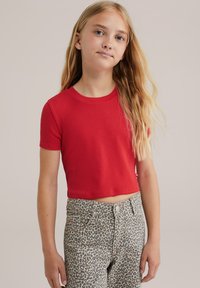 Vörös bordás crop top rövid ujjakkal, texturált leopárdmintás farmernadrággal párosítva. Szoros szabás, pamut keverék anyag.