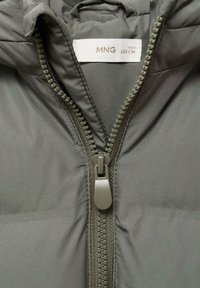 Sivá vypchatá bunda s kapucňou, s predným zipsom, ľahká textília a vnútorná nálepka uvádzajúca veľkosť 128 cm.