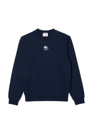 Granatowa bluza z długim rękawem i okrągłym dekoltem, z białym logo Lacoste i tekstem "Lacoste Paris" na środku klatki piersiowej.