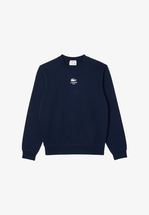 Granatowa bluza z długim rękawem i okrągłym dekoltem, z białym logo Lacoste i tekstem "Lacoste Paris" na środku klatki piersiowej.