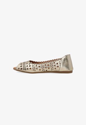 Goldener flacher Schuh mit offenem Zehenbereich, geometrischen Ausstanzmustern, gewellten Rändern und einer schlanken braunen Sohle.