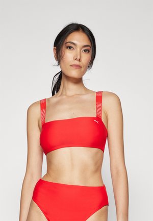 Ensemble de bikini rouge comprenant un haut bandeau avec des bretelles logo et un bas taille haute, fabriqué dans un matériau lisse et extensible.