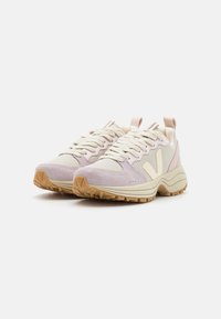 Sneaker leggere con tomaia in suede lavanda e mesh crema, con suola in gomma testurizzata e accenti di branding sottili.