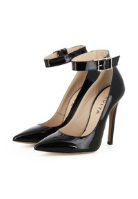 Decollete in vernice nera con punta affilata, cinturino alla caviglia e tacco a stiletto slim. L'interno presenta una soletta beige.