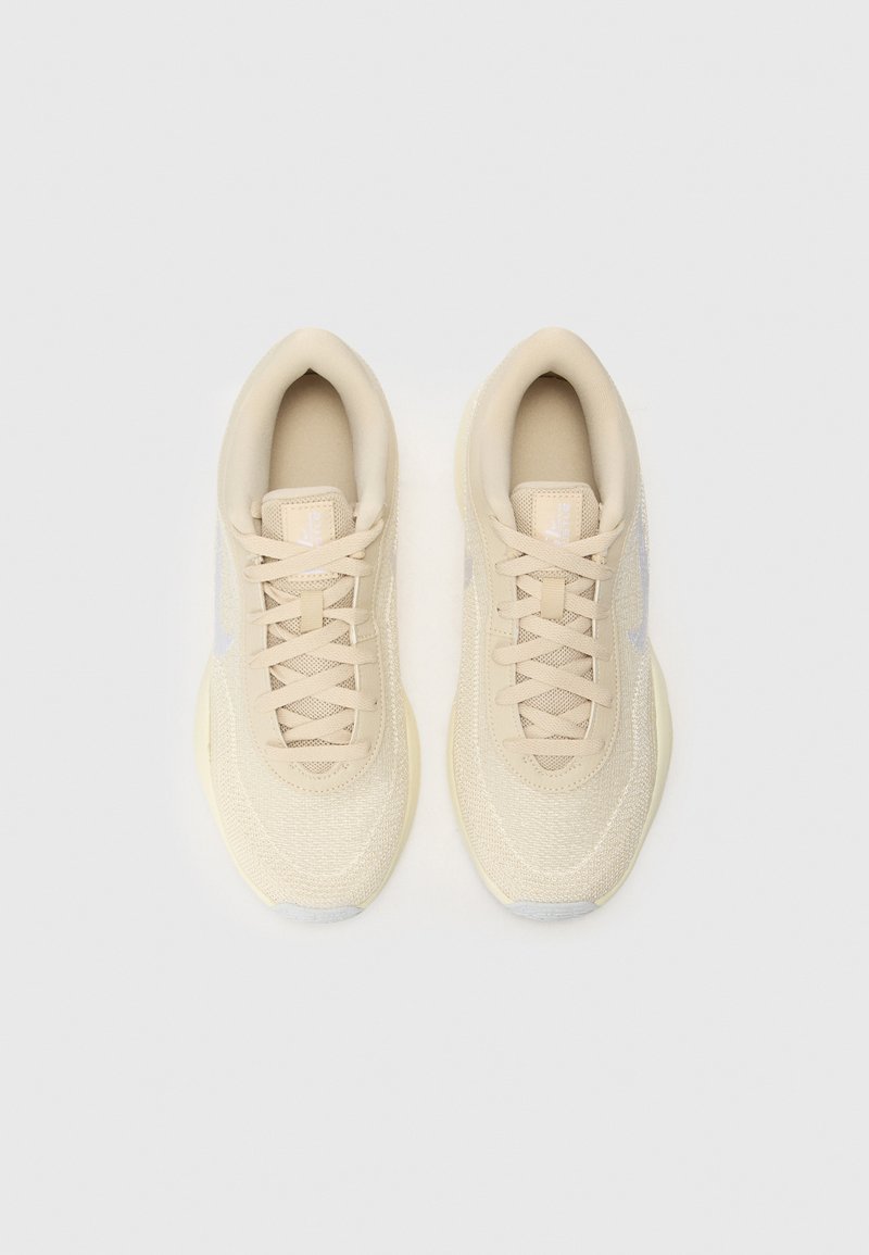Beige Sportschuhe aus atmungsaktivem Mesh, mit einer strukturierten Oberfläche, abgerundetem Zehenbereich und Schnürsenkeln. Dezente Akzente in Hellgrau.