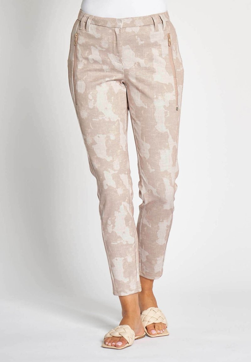 Light beige pants with a subtle camouflage pattern, featuring zip pockets and a tailored fit. Made from breathable fabric.