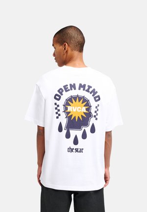 Man draagt een wit t-shirt met een afbeelding van een hoofd silhouet, zonnestralen en tekst "OPEN MIND RVCA the star" op de achterkant.