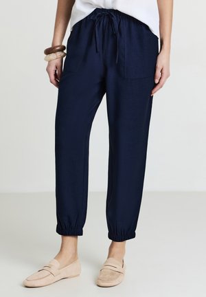 Navy blue jogger pants made of soft fabric with an elastic waistband, drawstring, and two front pockets; cuffed ankles.