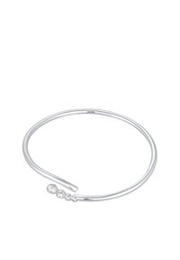 Silverfärgad metallarmband i cuff-stil med en slät, rundad design, prydd med fem små, klara ädelstenar som är arrangerade i en gradient längs ena sidan.