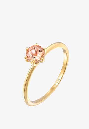 Guldring med en oval ferskenfarvet ædelsten sat i seks fanger. Glat ring, poleret overflade, subtile mærker indvendigt.