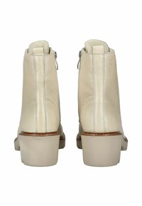 Bottines en cuir beige avec une finition lisse, des fermetures éclair sur le côté et des talons épais de couleur claire. Coutures décoratives le long des côtés.