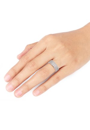 Silberner Ring mit strukturiertem Oberflächen, breitem Band und filigranen Details. Wird an einer Hand mit natürlich manikürten Nägeln getragen.