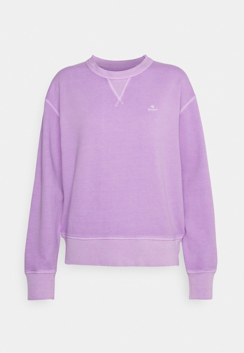 Sudadera morada con cuello redondo, confeccionada con tela suave y con puños y dobladillo acanalados. Presenta un pequeño logo en el pecho y detalles de costuras en contraste.