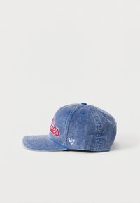 Μπλε καπέλο από κορδούρα με ελαφρώς κυρτή γείσο, με κόκκινα κεντημένα γράμματα "lies" και ένα μικρό λευκό λογότυπο στο πλάι.