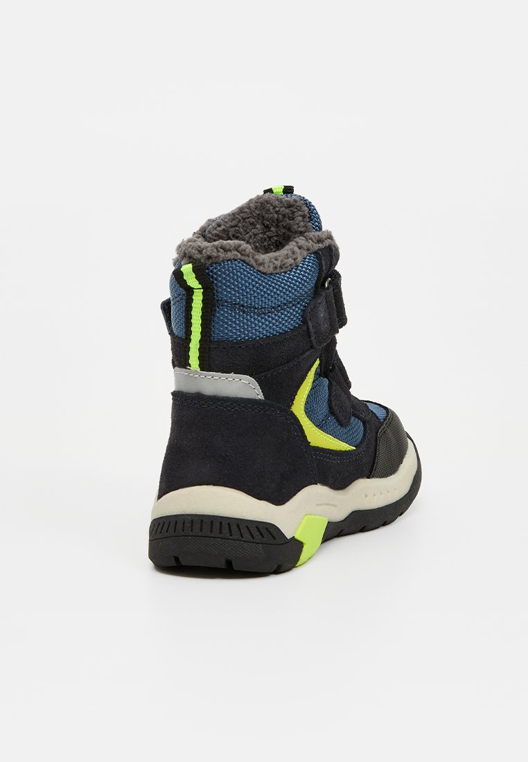 Kinderschuhe mit einem Obermaterial aus navy-blauem Wildleder und blauer Textilie, reflektierenden Akzenten in Neon-Grün, grauem Kunstfell-Futter und einer robusten schwarzen Sohle.