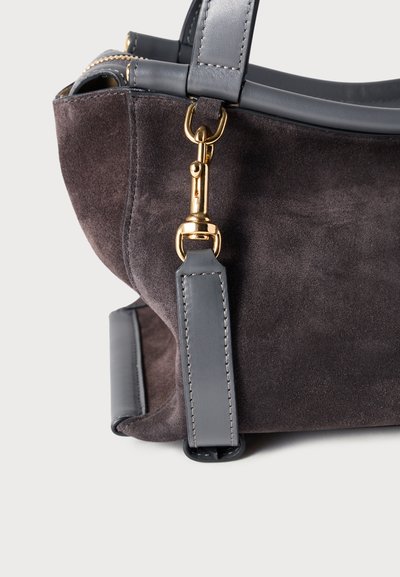 Τσάντα χειρός από γκρι σουέντ με λείες γκρι δερμάτινες λεπτομέρειες. Διαθέτει κούμπωμα με μεταλλικό στοιχείο σε χρυσή απόχρωση και δομημένο σχήμα. Ορατή υφή με ανάγλυφη επιφάνεια.