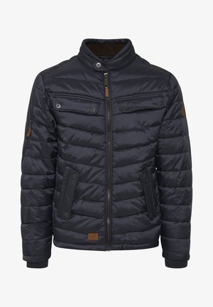 Tums zila pūkalu mētelis ar augstu apkakli, rāvējslēdzēja aizdari, četriem ārējiem kabatām, ribota apkakle un brūnu ādas akcentiem.