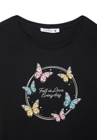 Maglietta nera con una grafica rotonda che presenta farfalle multicolori e la frase "Innamorati ogni giorno" in carattere bianco.